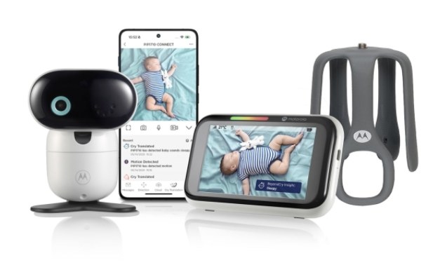 Hvidt Motorola-kamera, en telefon og en skærm, der viser en sovende baby, og en grå holder til tremmesengen